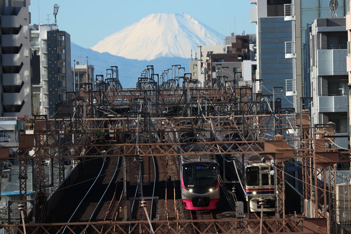 新春のビルの谷間を行く京王線の写真