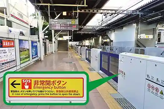 ホームに設置されたホームドアと「非常開ボタン案内」の拡大写真